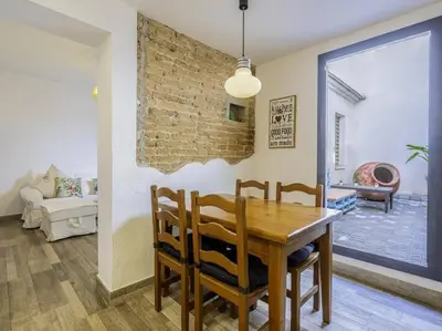 a dining room with a wooden table and chairs at Casa Mediterránea en Badalona in Badalona