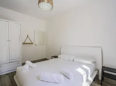 a white bedroom with a white bed with towels on it at Casa Mediterránea en Badalona in Badalona