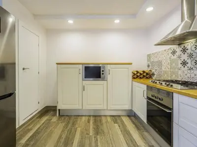 a kitchen with white cabinets and a microwave at Casa Mediterránea en Badalona in Badalona