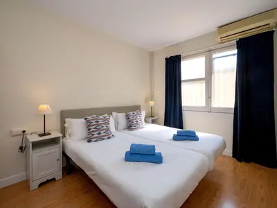 a bedroom with a large white bed with blue pillows on it at Apartment Sagrada Familia- Rossello by Interhome in Barcelona