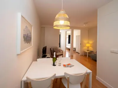 a dining room and living room with a white table and chairs at Apartment Sagrada Familia- Rossello by Interhome in Barcelona