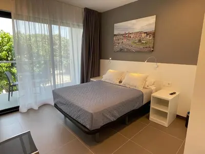 a bedroom with a bed and a large window at Hotel C31 in Castelldefels