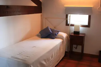 a bedroom with a bed and a lamp and a window at Cal Negre 2 in Vilassar de Mar