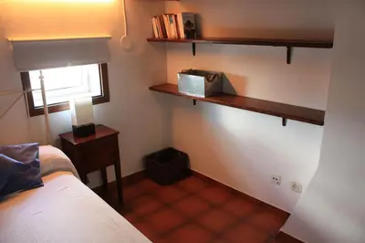 a bedroom with a bed and a table and a window at Cal Negre 2 in Vilassar de Mar