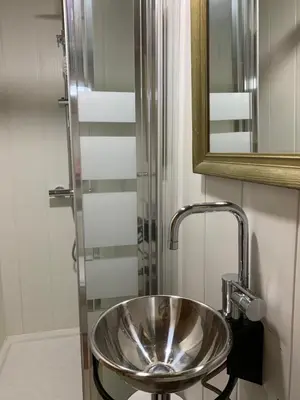 a bathroom with a silver sink and a shower at Cal General in San Vicente de Castellet