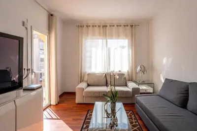 a living room with a couch and a table at The Collection Barcelona - Eixample - Bright and modern 4BD only for Families or Business groups in Barcelona