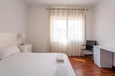 a white bedroom with a desk and a chair at The Collection Barcelona - Eixample - Bright and modern 4BD only for Families or Business groups in Barcelona