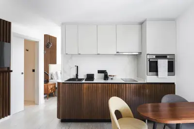 a kitchen with white cabinets and a table and chairs at master La Rambla in Barcelona