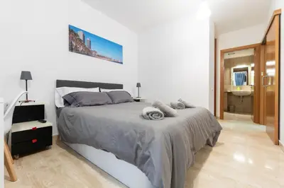 a bedroom with a large bed and a bathroom at Apartament Granollers Up Live I in Granollers