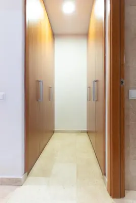 a hallway with wooden doors and a tile floor at Apartament Granollers Up Live I in Granollers