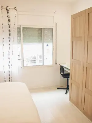 a bedroom with a bed and a desk and a window at Apartamento 15' Barcelona centro in Santa Coloma de Gramanet