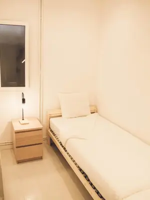 a small bedroom with two beds and a night stand at Apartamento 15' Barcelona centro in Santa Coloma de Gramanet