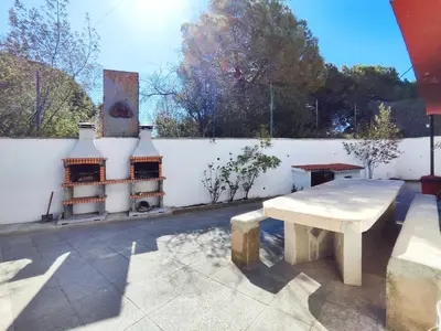 a white fence with a bench and a table at Casa con piscina privada en Sant Pol de Mar in San Pol de Mar