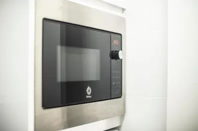 a microwave oven is attached to a wall at Ático en Calella a 7 minutos de la playa in Calella