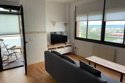 a living room with a couch and a flat screen tv at Apartment with sea views next to the beach of Mar Bella in Barcelona